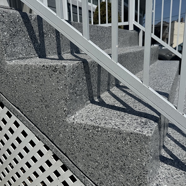 Marches d'escalier extérieur réparées et recouvertes d'époxy à granules gris, réalisation VirezSulTop Époxy Design en Montérégie.