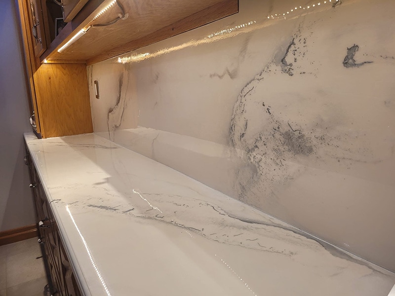 Comptoir et dosseret en époxy effet marbre blanc et gris avec éclairage DEL intégré, réalisation VirezSulTop Époxy Design en Montérégie.