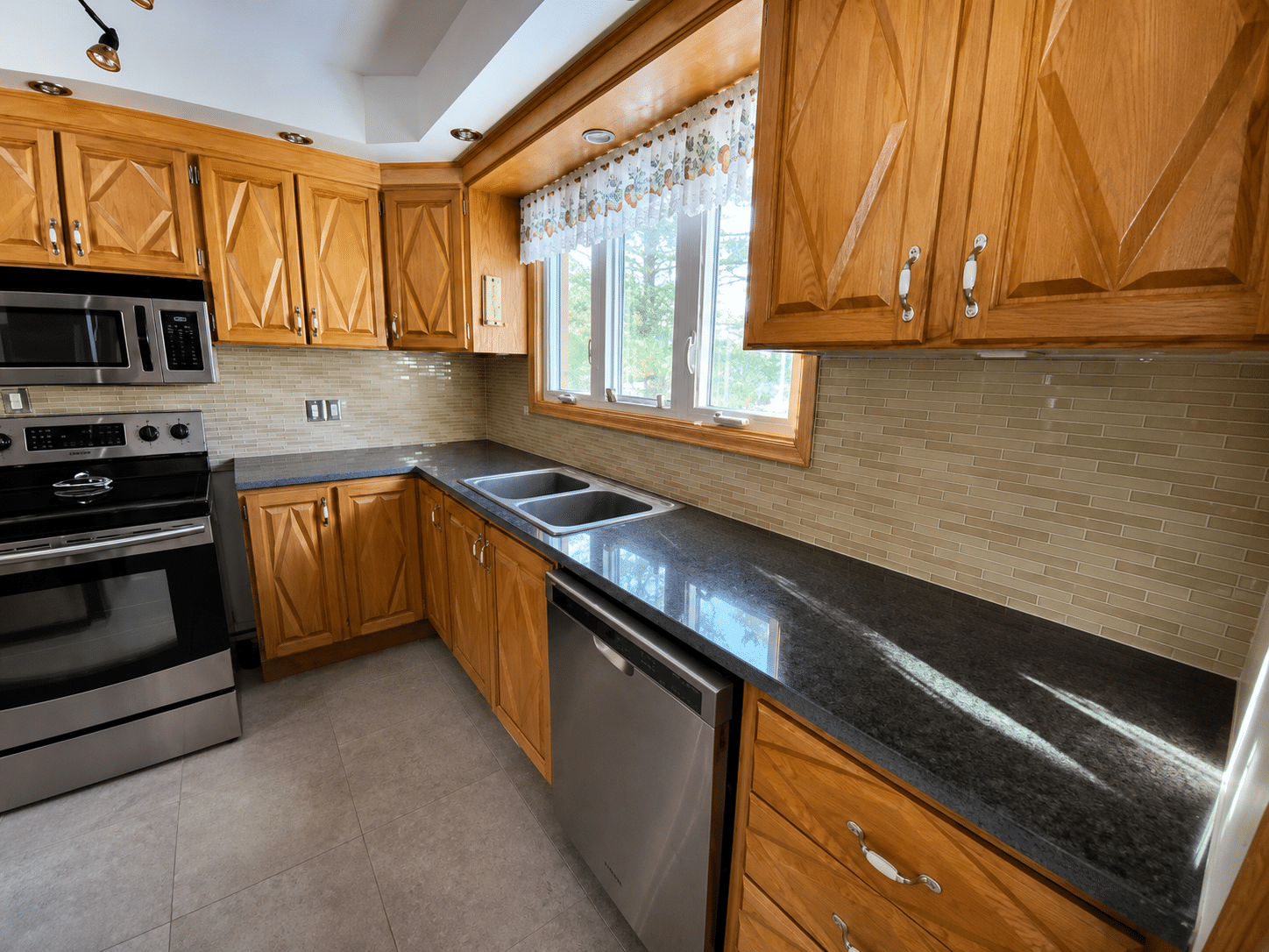 Cuisine avec comptoir foncé avant transformation en époxy, armoires en bois et céramique beige, projet VirezSulTop Époxy Design en Montérégie.