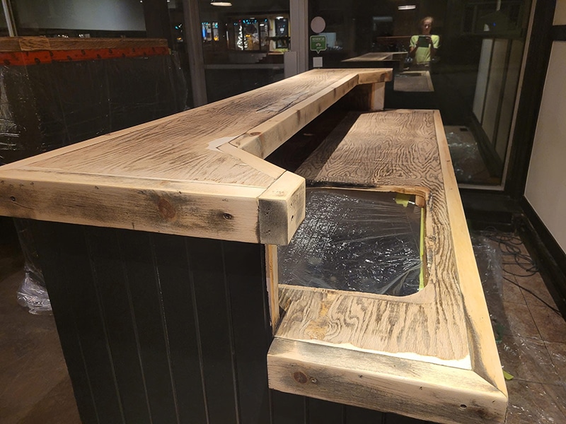 Comptoir de bar en bois brut avant application époxy, structure en construction dans commerce, projet VirezSulTop Époxy Design en Montérégie.