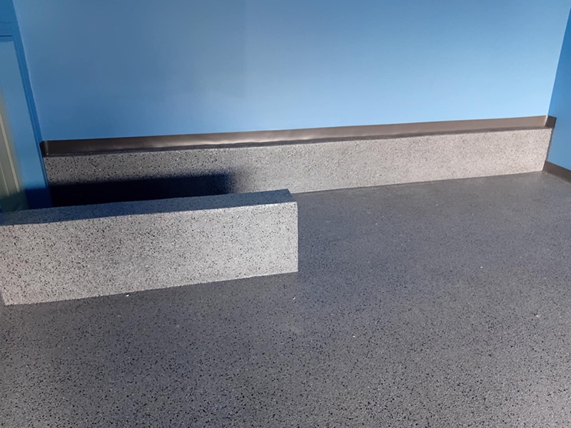 Plancher et plinthes en époxy à granules gris avec bordure noire, revêtement commercial durable, réalisation VirezSulTop Époxy Design en Montérégie.