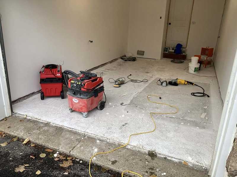 Plancher de garage en béton poncé avant application époxy, préparation avec équipement de meulage, projet VirezSulTop Époxy Design en Montérégie.